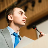 Man speaking from a lectern at a meeting