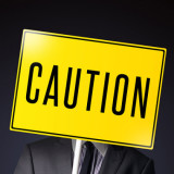 man holding a Caution sign