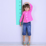 photo of a young girl measuring her height against a wall