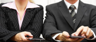 Using smartphone or computer tablet during a meeting.